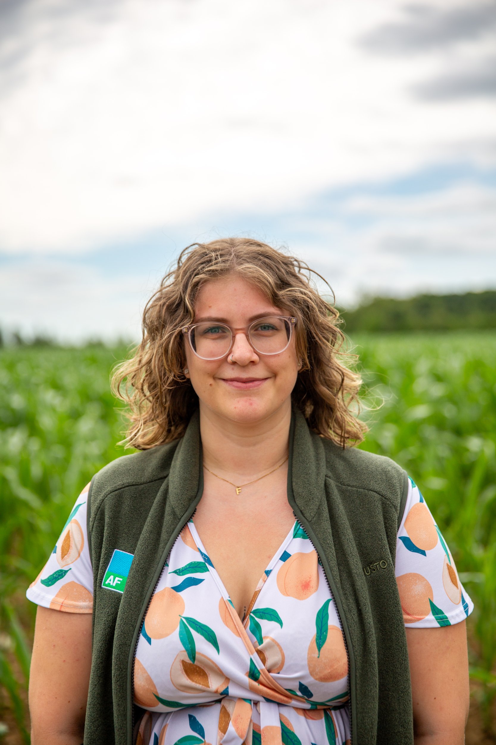 Portrait of Annalise Crisp, AF Crop Inputs and Pest Control Specialist, wearing a green gilet and glasses